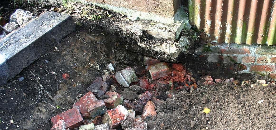 Tree stump removed and underpinned with bricks and concrete